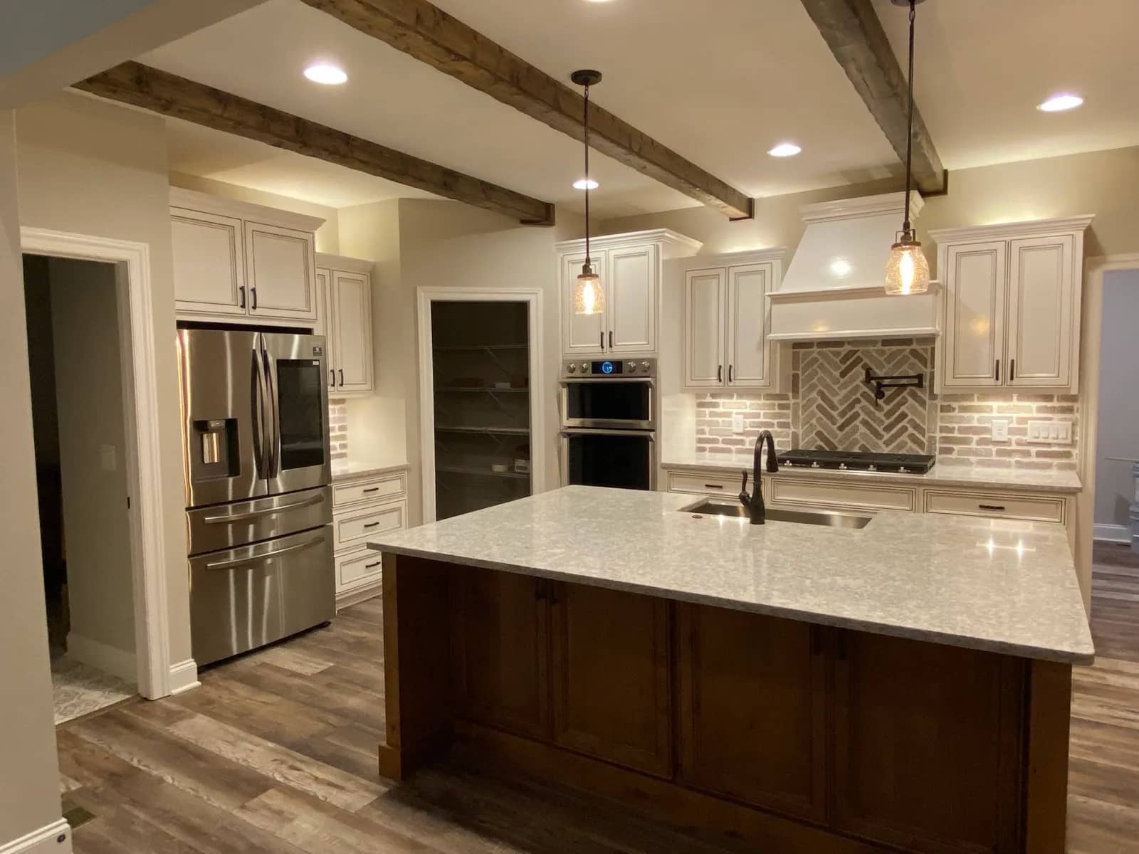 Renovated kitchen with custom cabinetry, a quartz-topped island, wood ceiling beams, and a brick backsplash in Middle Tennessee